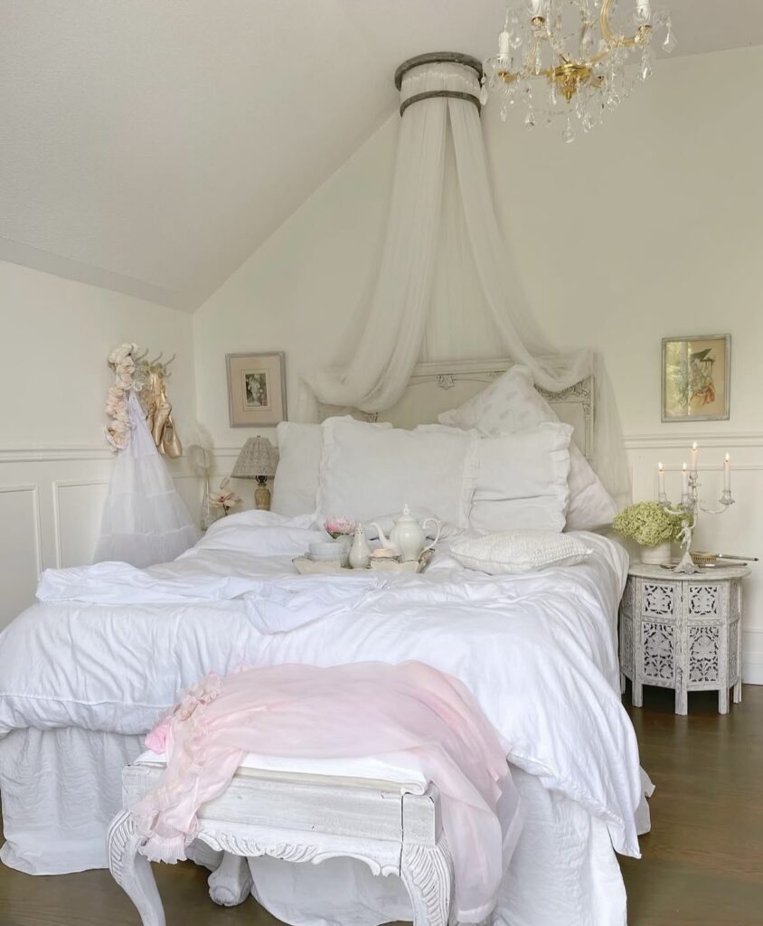 A coquette bedroom with white bedding.