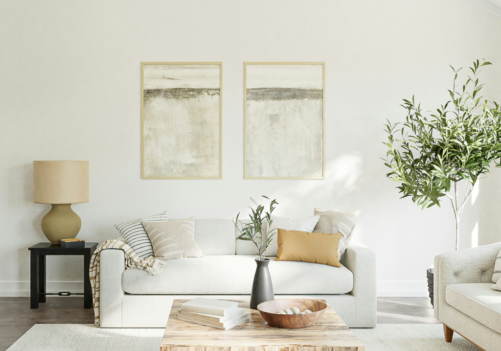 A white sofa with neutral artworks.