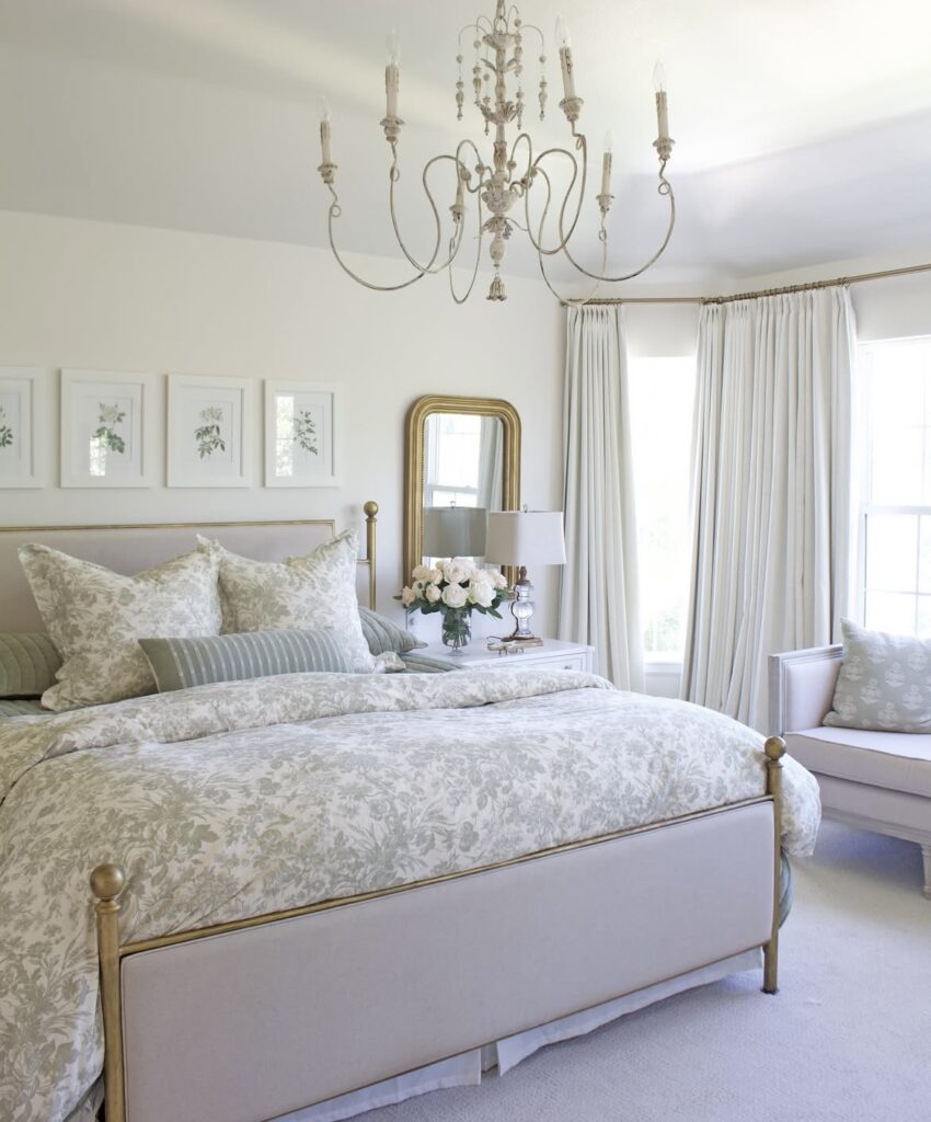 A bedroom with a crystal chandelier.