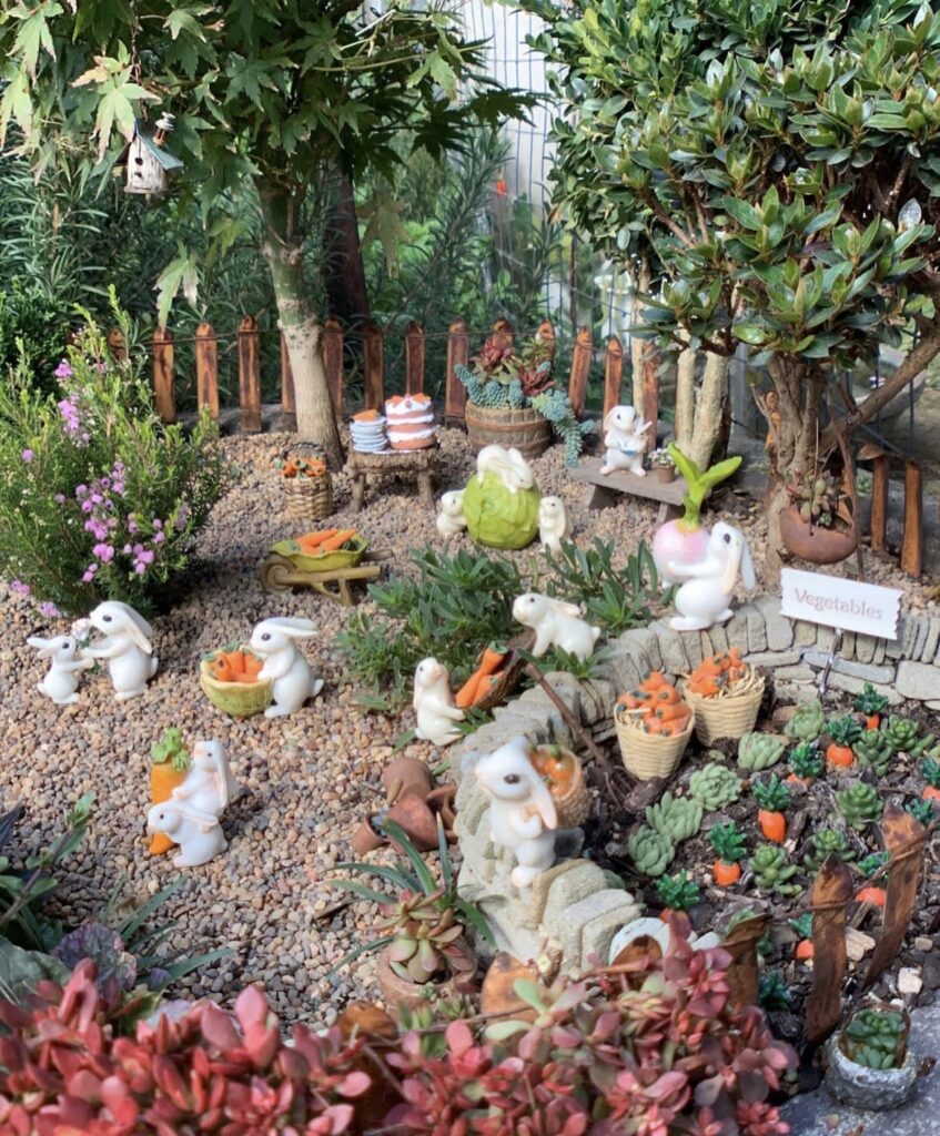 A miniature garden filled with rabbit figurines.