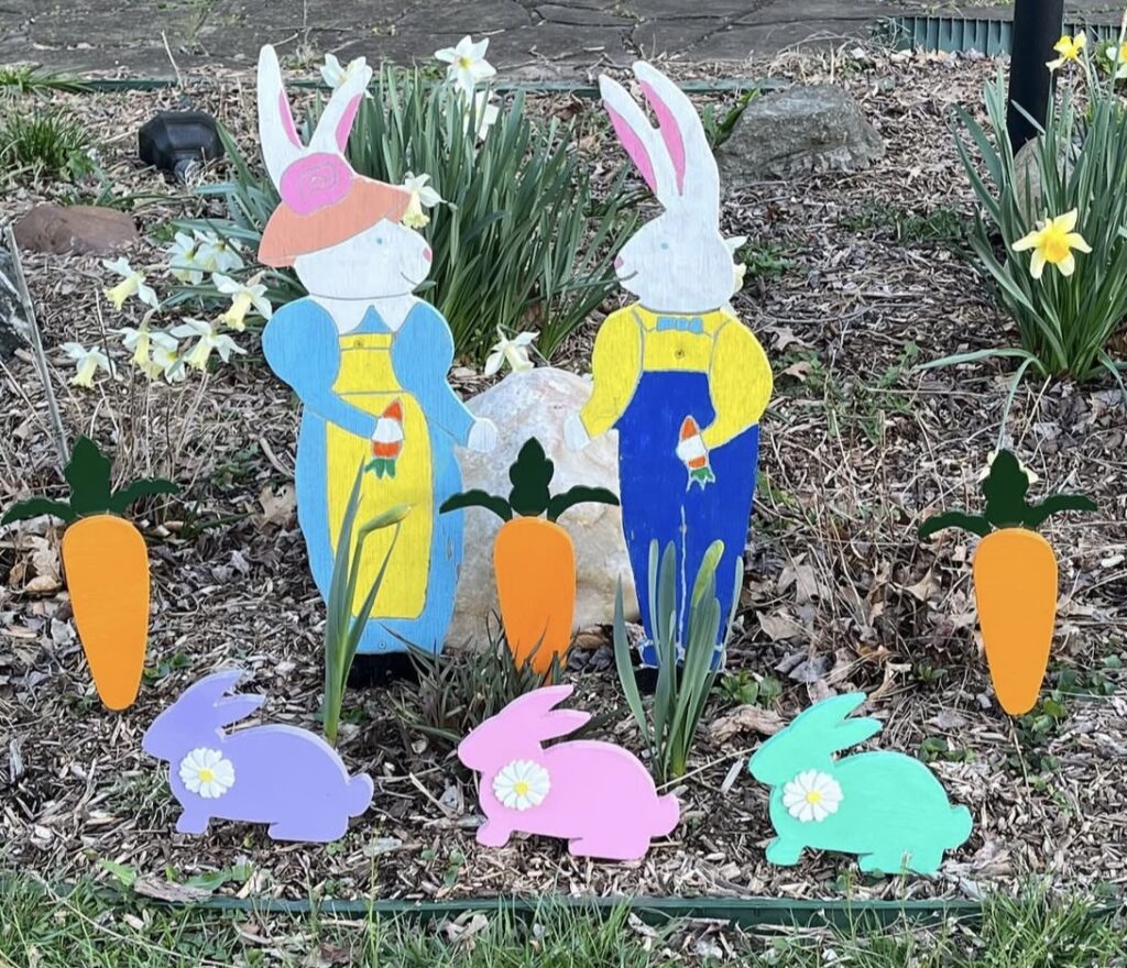 Rabbit and carrot cutouts in a garden.