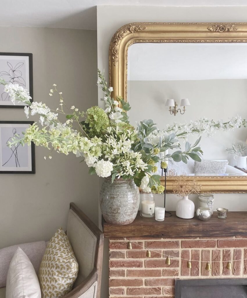 A floral arrangement on a fireplace.