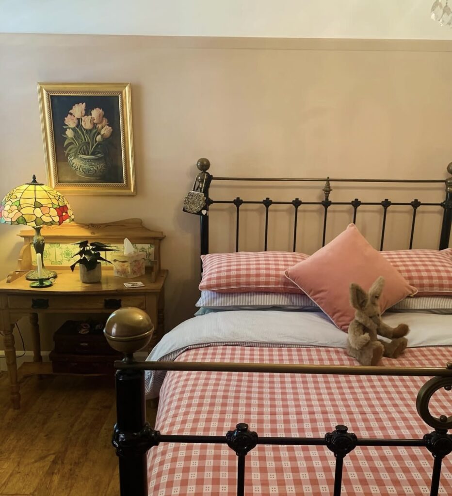 A traditional bedroom with a stained glass lamp.