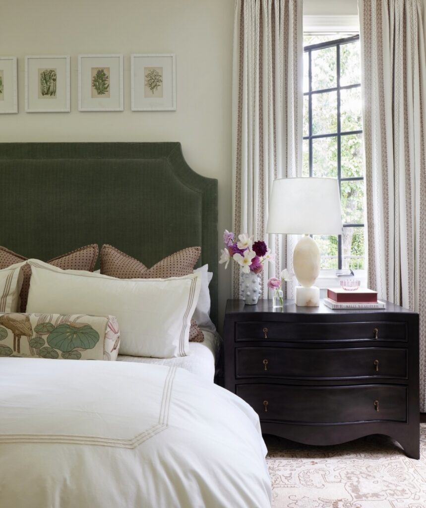 A modern bedroom with a dark green headboard.