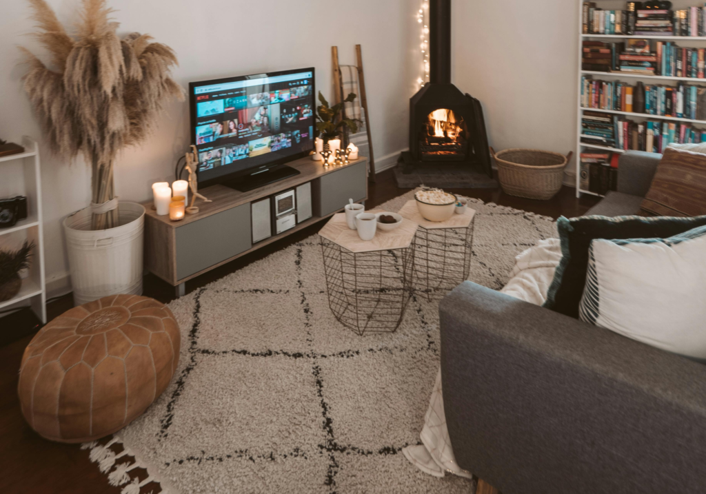 A cozy living room with candles and a textured rug.