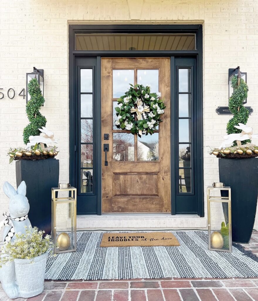 Gold Easter eggs with rabbit figurines on a front porch.