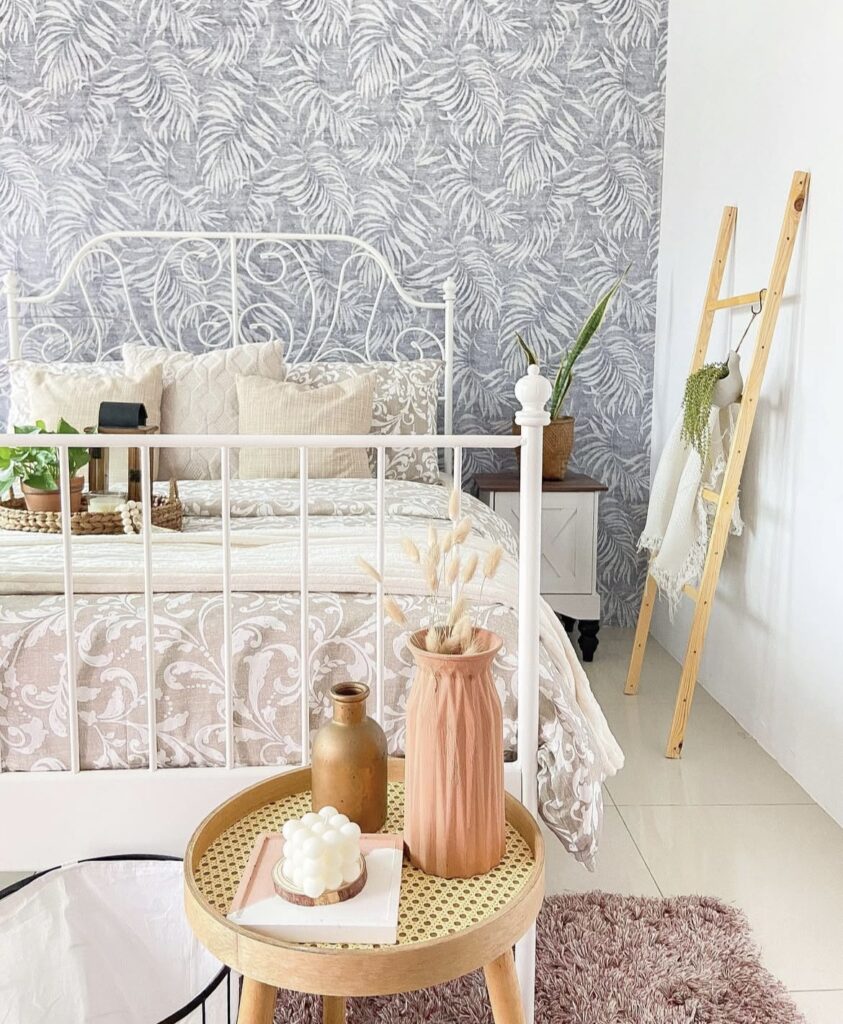 A bedroom with a floral wallpaper.