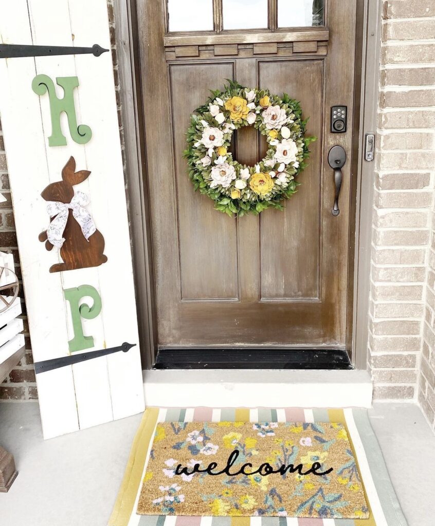 A hop sign on a front porch and a wreath on a front door.