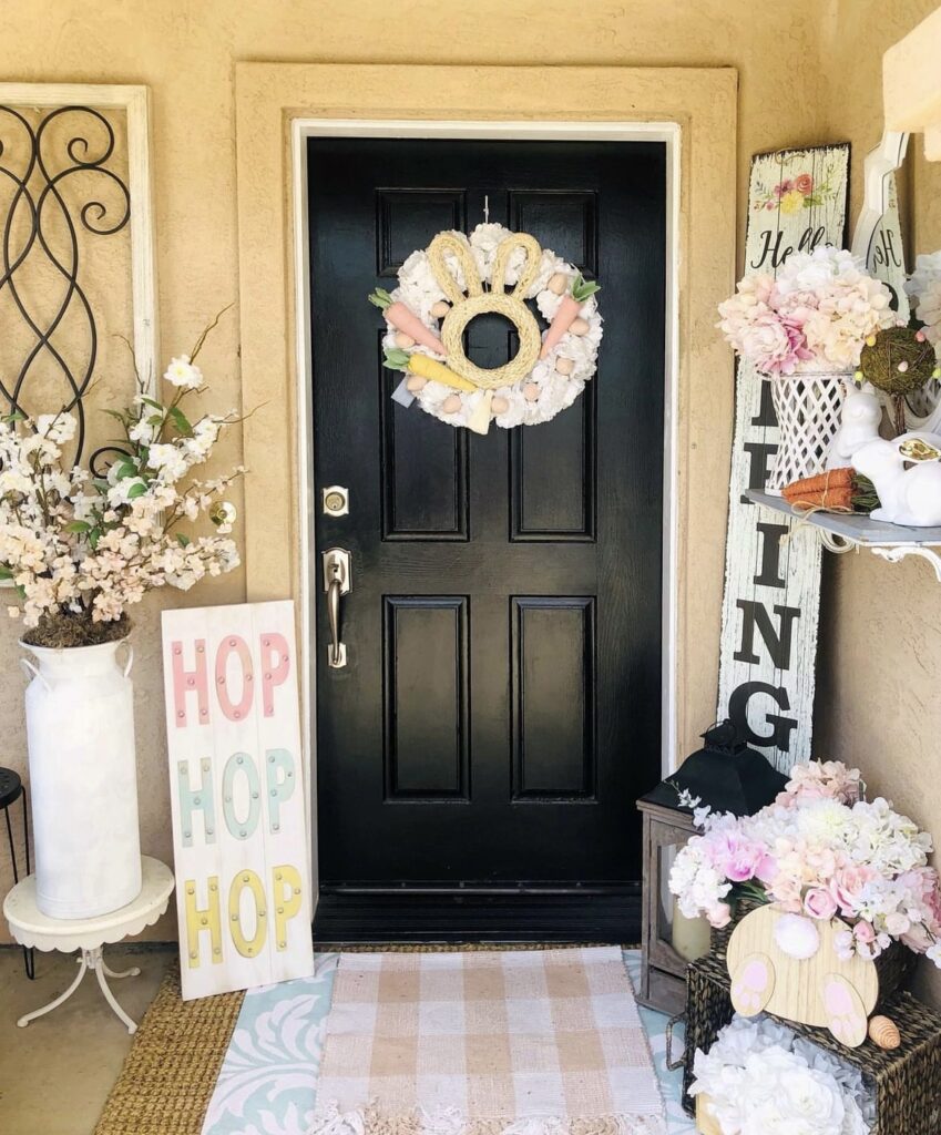 A wreath on a black front door and Easter signs on a front porch.