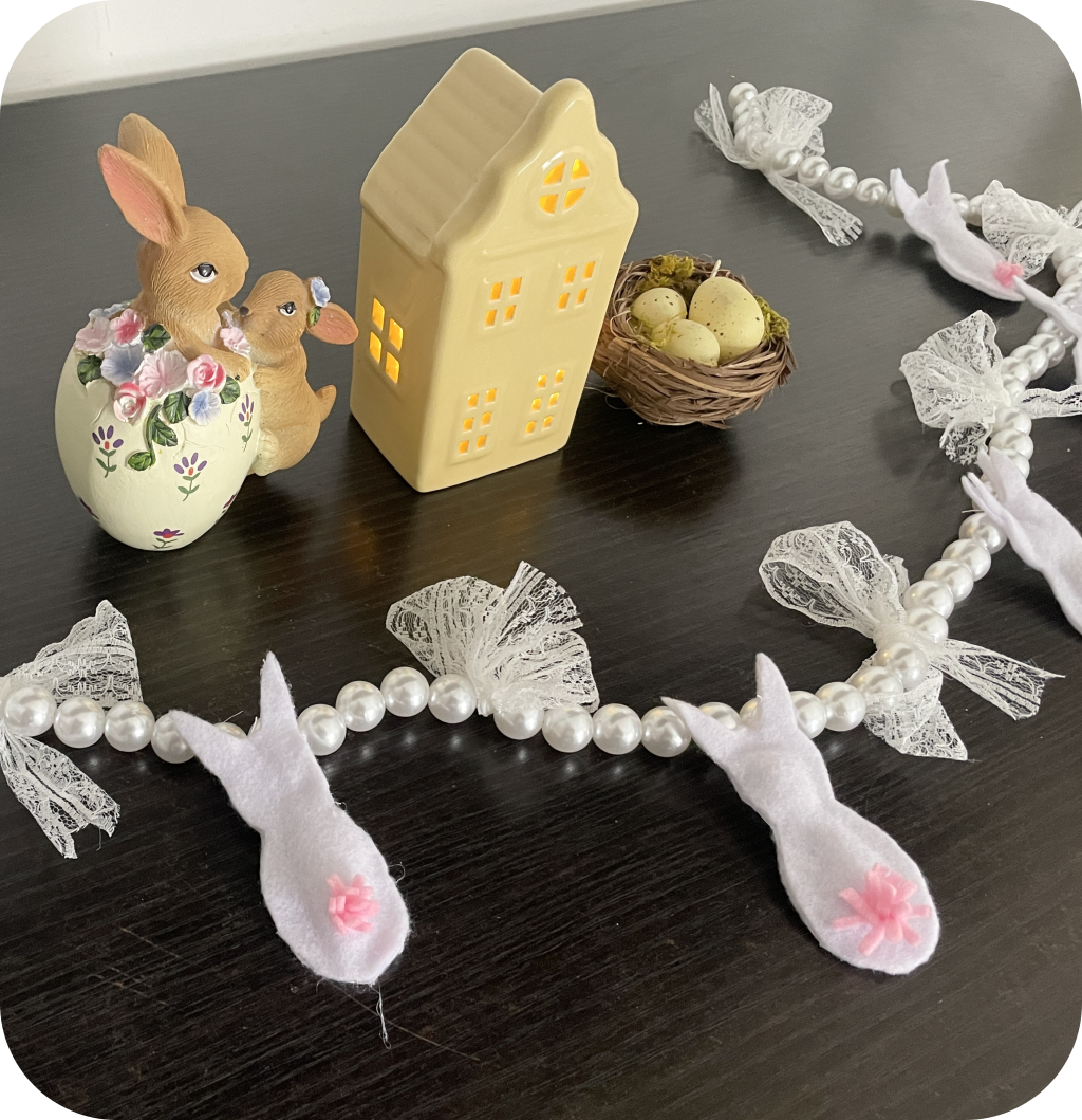 An Easter bunny garland made of white felt bunnies, fake pearls and lace bows. ©ASTRAPEARL - DO NOT USE