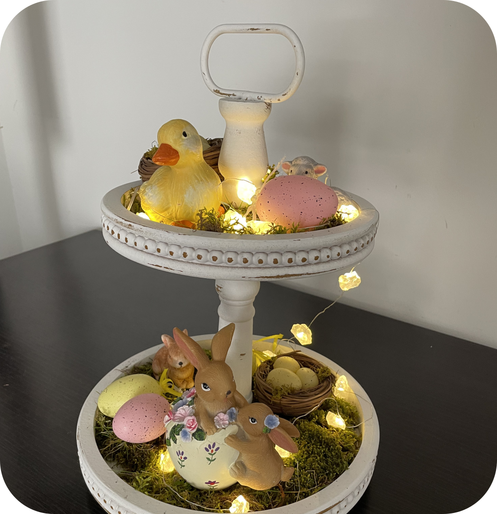 A 2 tiered tray with Easter figurines, Easter eggs, moss and a LED garland. ©ASTRAPEARL - DO NOT USE