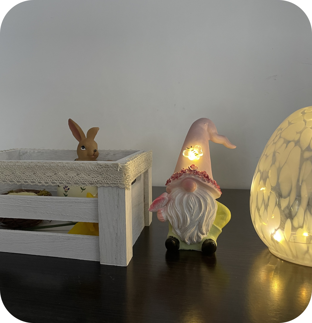 A white bow with a bunny figurine and daffodils, an Easter gnome and a large Easter egg. ©ASTRAPEARL - DO NOT USE