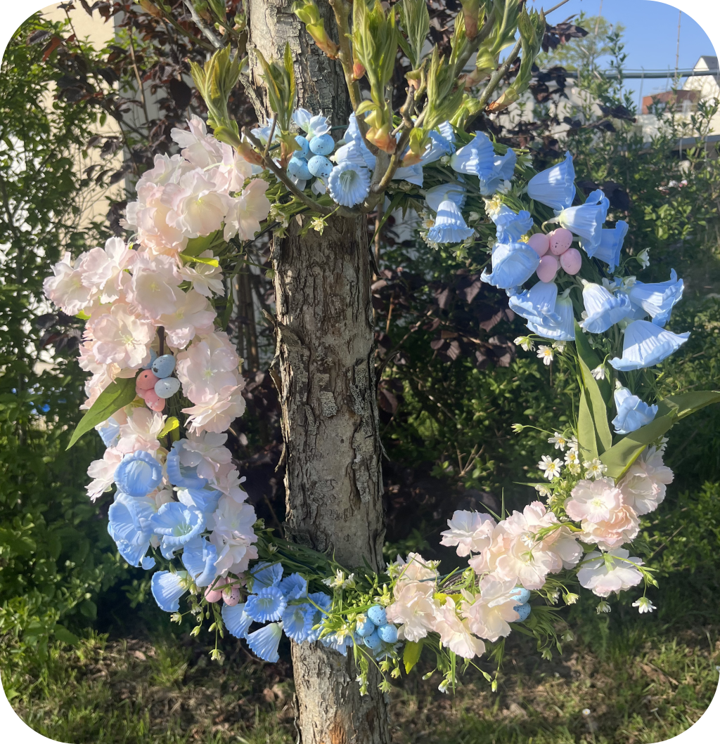 Easter egg wreath made of blue and pink fake flowers with small Easter eggs. ©ASTRAPEARL - DO NOT USE