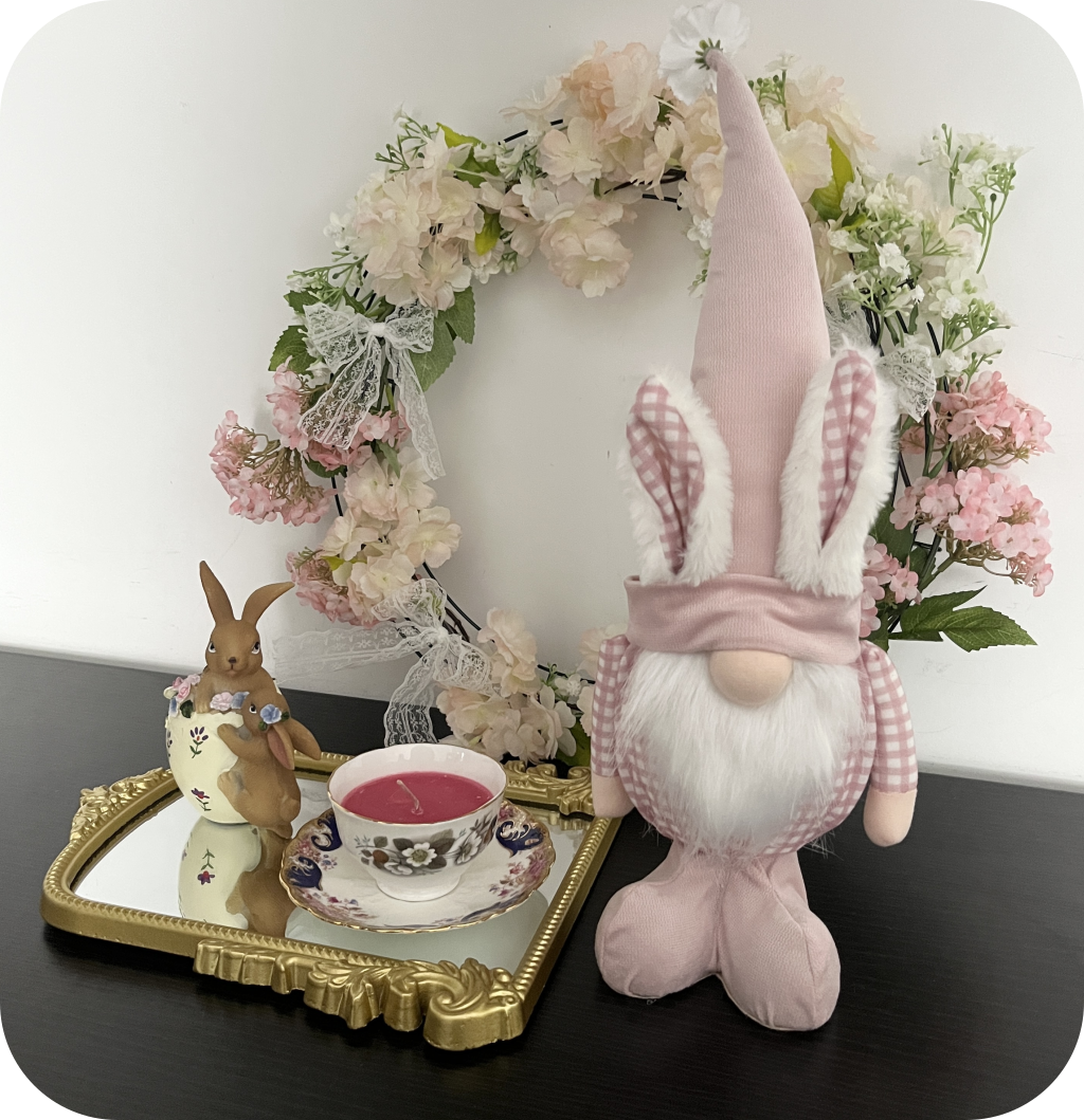 A vintage mirror with a bunny figurine, a candle, an Easter gnome, and an Easter wreath. ©ASTRAPEARL - DO NOT USE