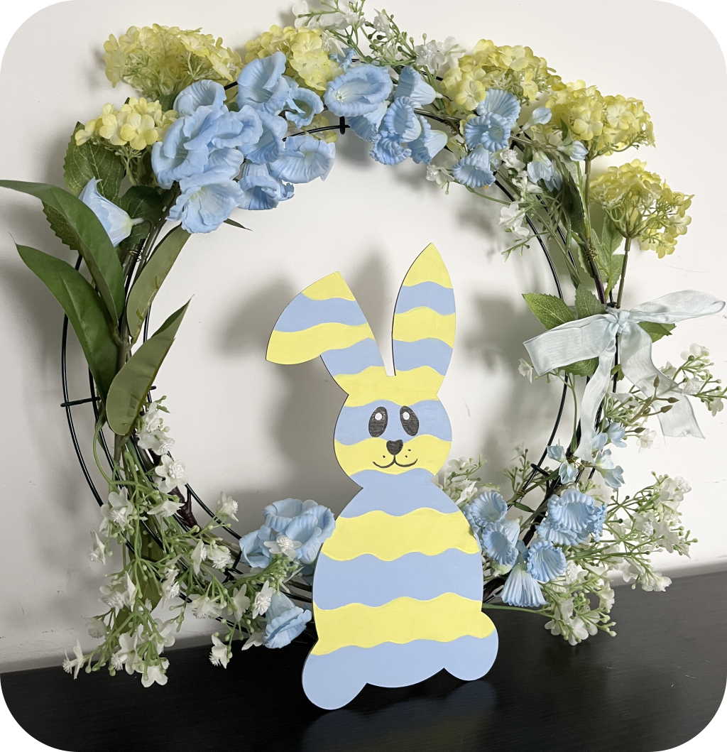 A blue and yellow floral wreath with a bunny cutout. ©ASTRAPEARL - DO NOT USE