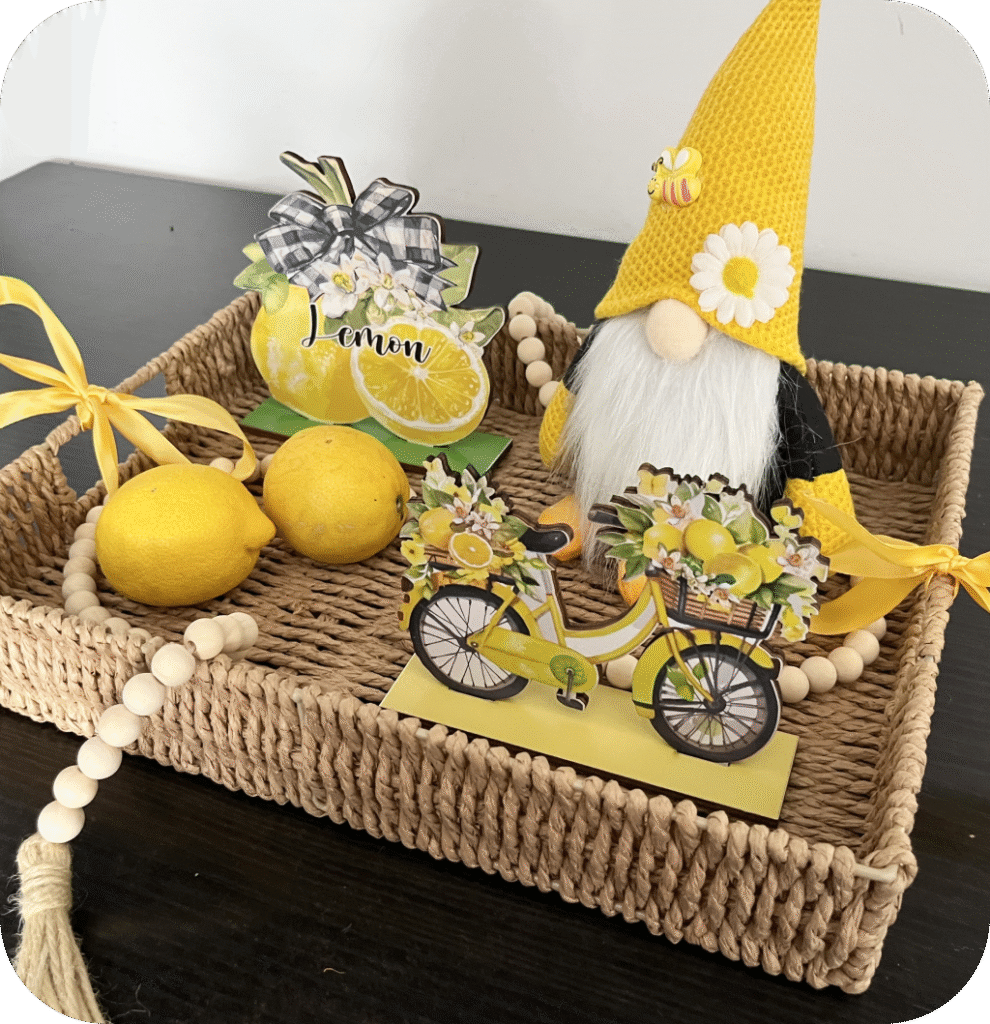 A woven tray with a bumble bee gnome, lemons, and lemon signs.