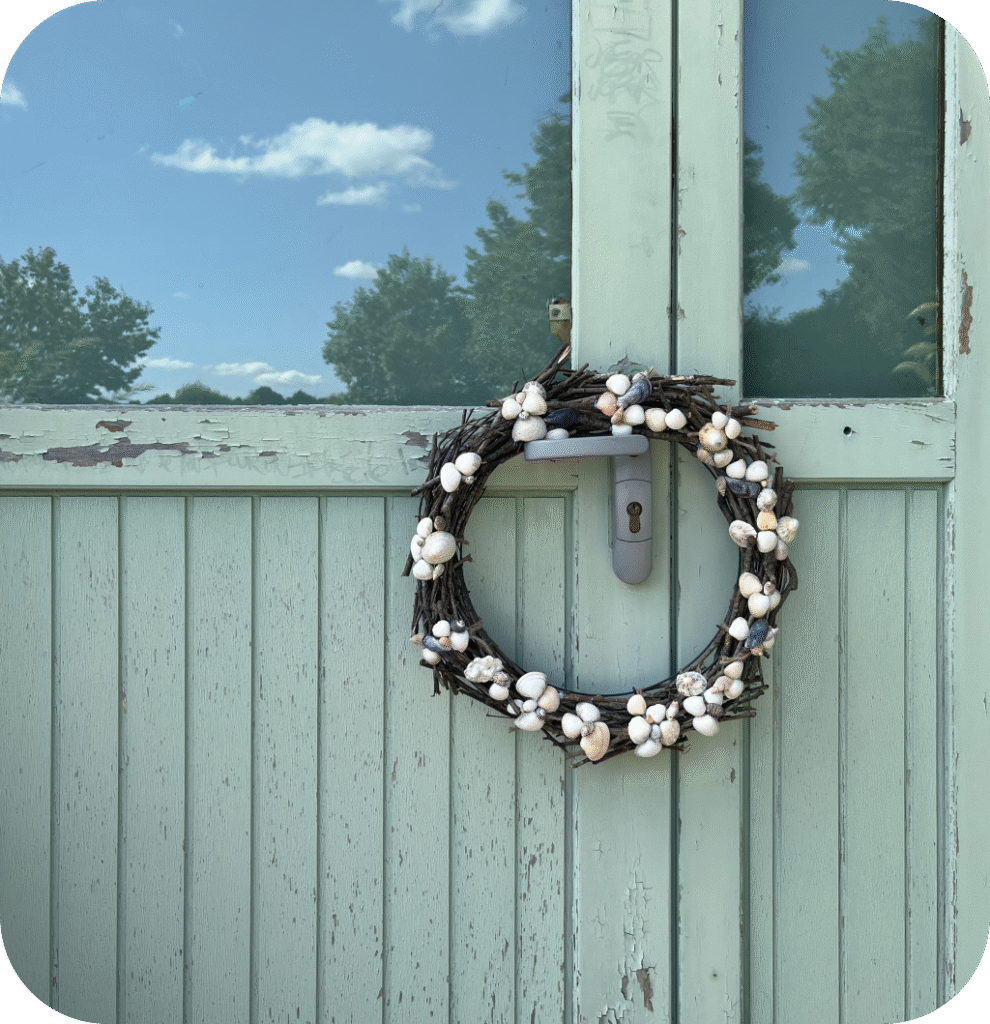 A seashell wreath on a blue door.