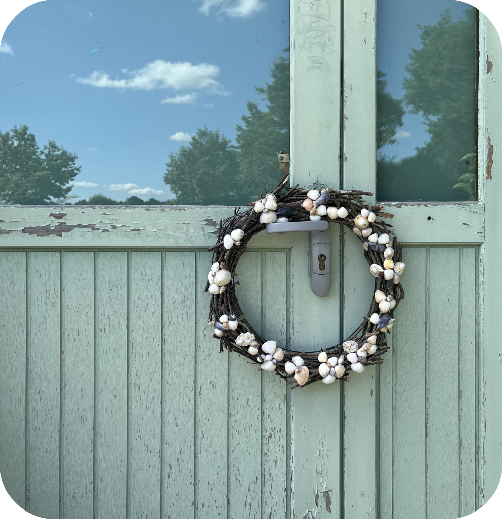 A seashell wreath on a blue door.