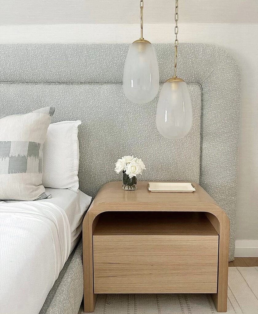 A curved nightstand with modern light fixtures.