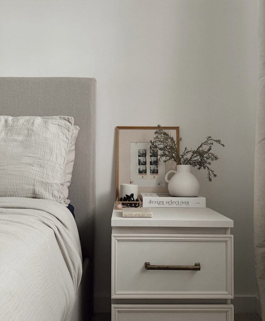 A white nightstand with personal pictures.