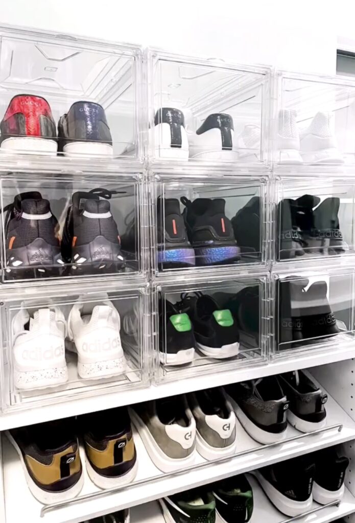 Shoes in clear bins in a bedroom.