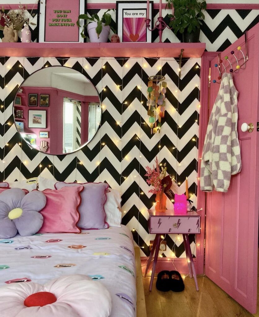 A pink bedroom with patterns and lights.