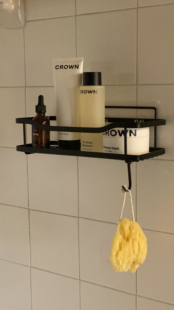 A black wall mounted organizer in a shower.