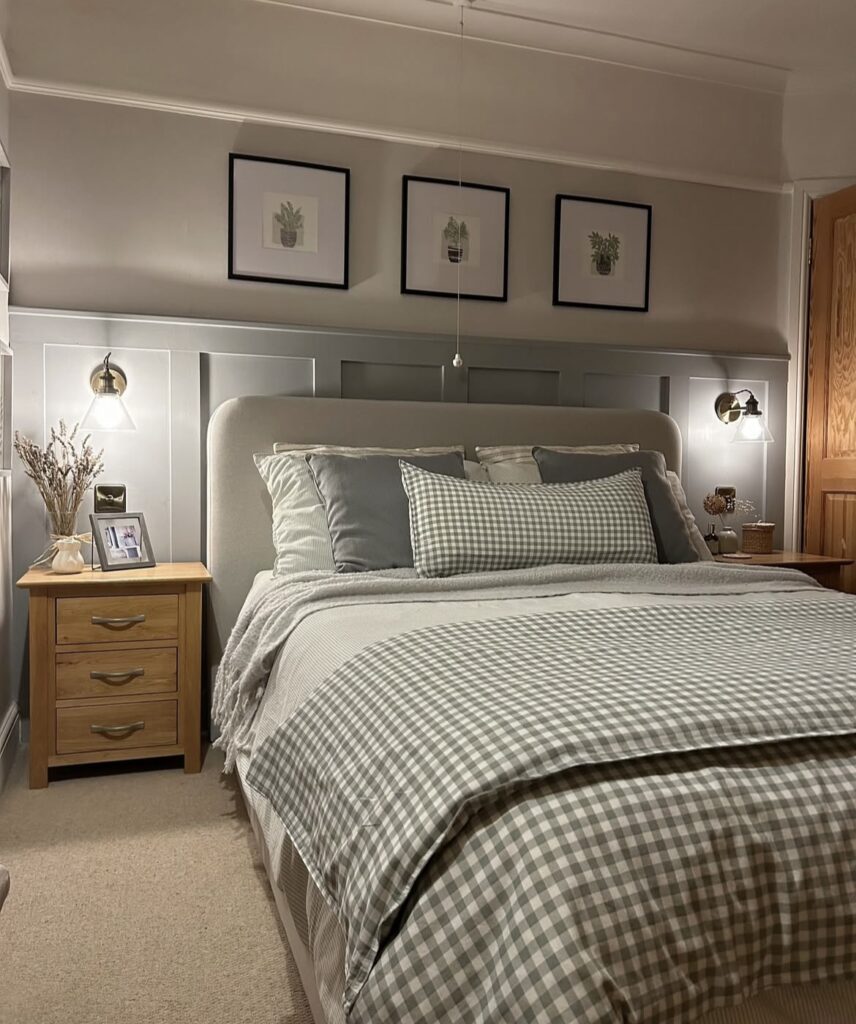 A bedroom with half wall paneling and 3 framed prints.