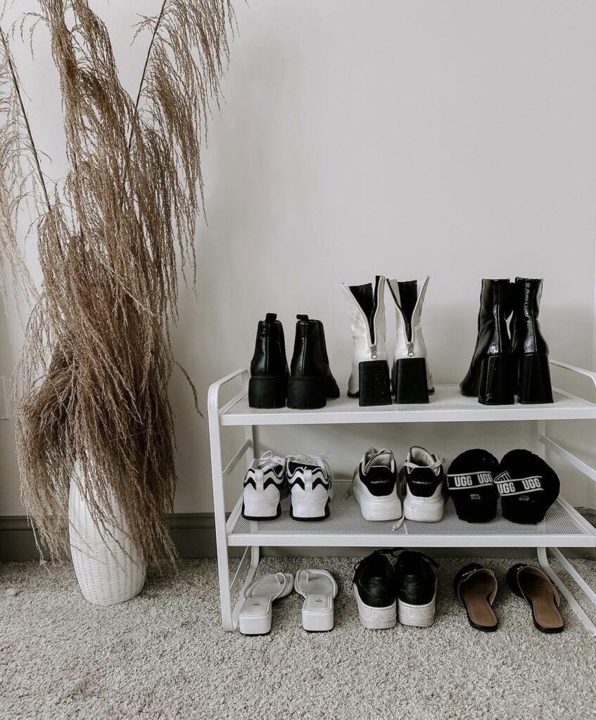 A white metal shoe rack in a bedroom.