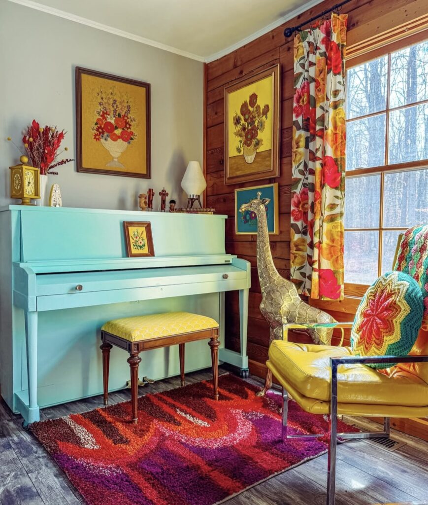 A blue piano with a giraffe statue.
