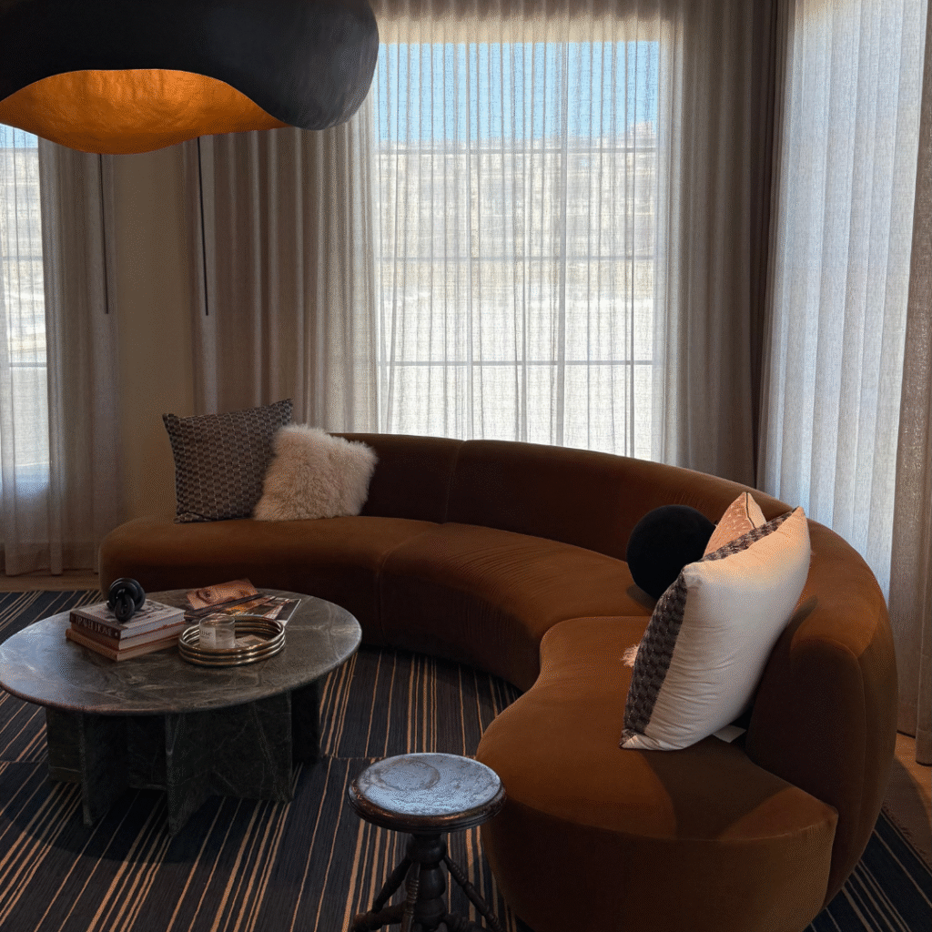 A brown living room with a large sofa.
