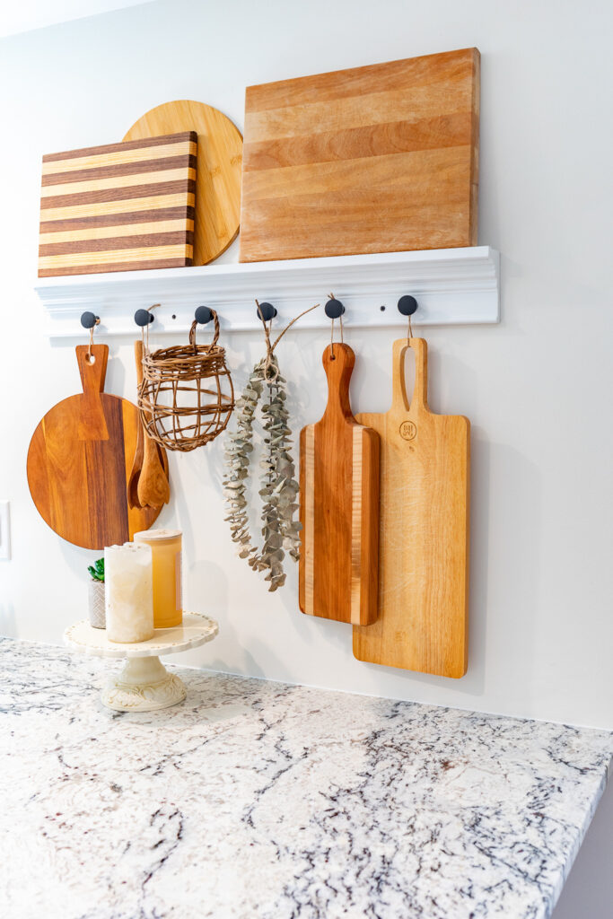 A white wall-mounted kitchen rack with kitchen utensils.