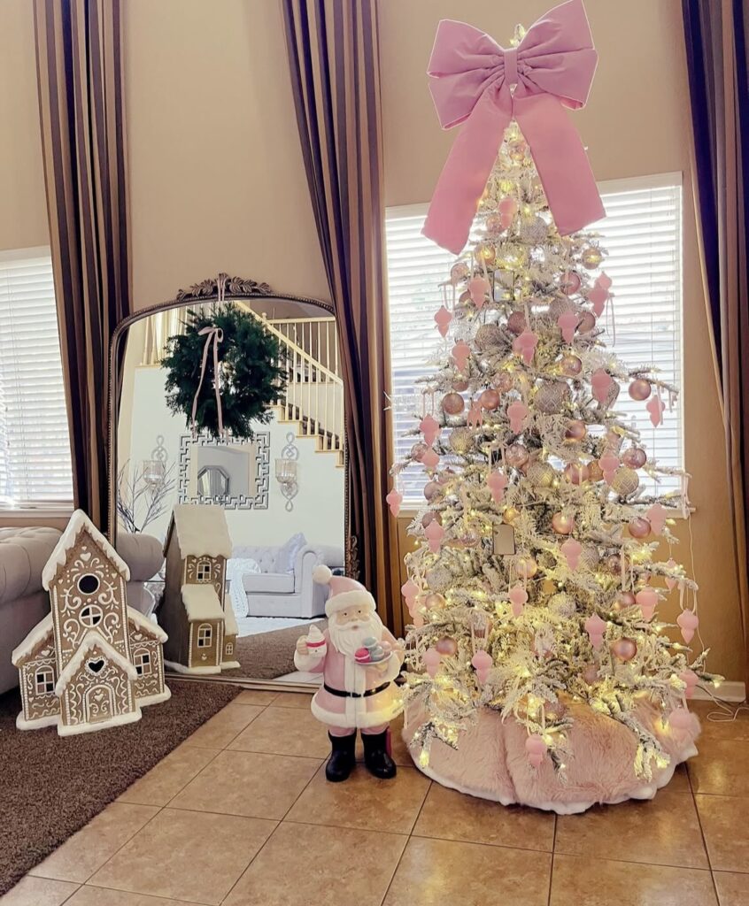 A white Christmas tree with pink ornaments and a pink Santa Claus.