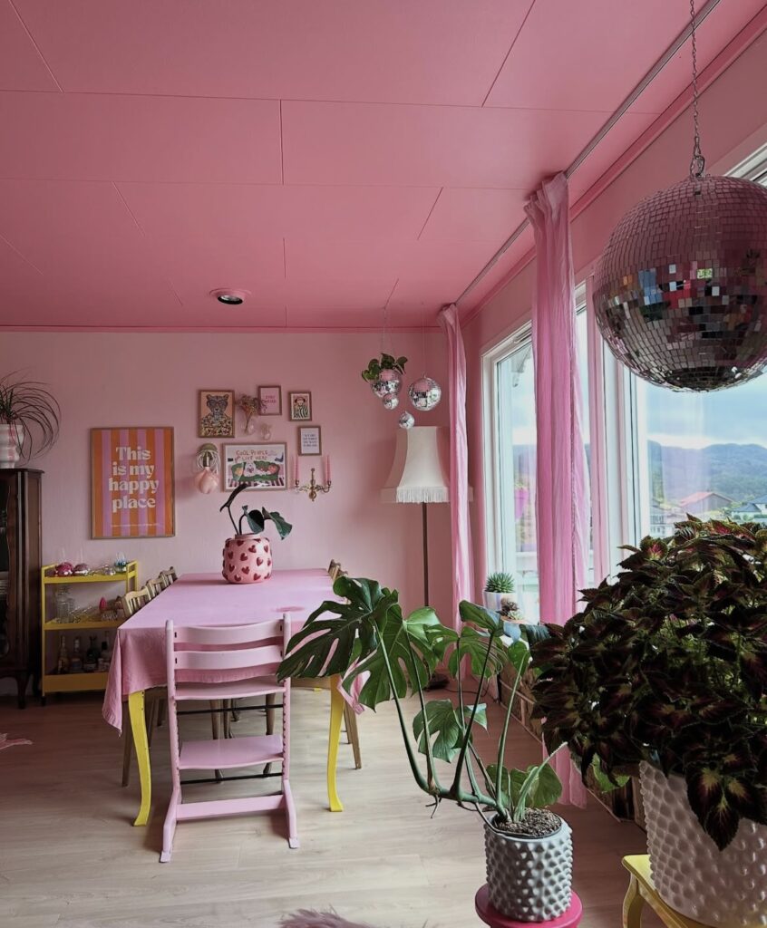 A living room with pink walls, a pink ceiling and a pink table.