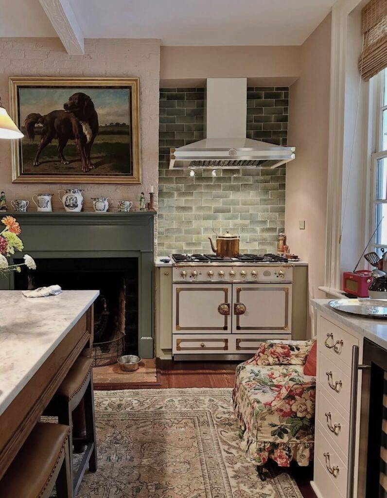 A sage green traditional kitchen with an antique painting.