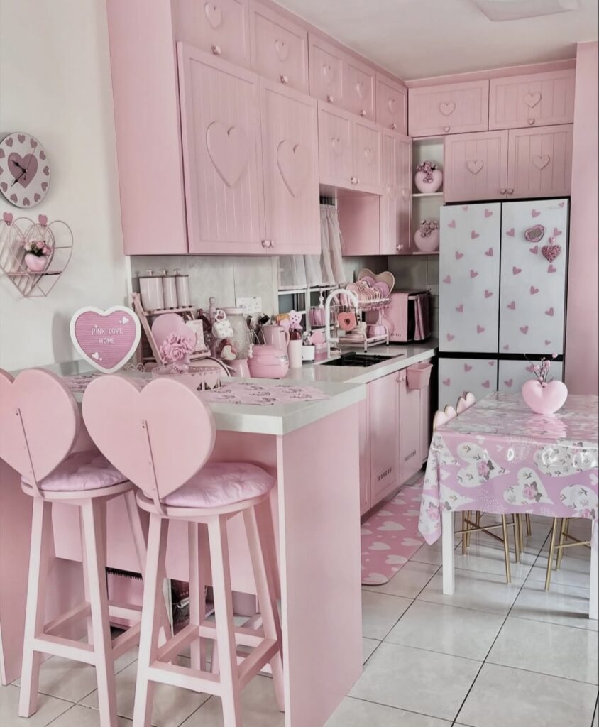 A pink kitchen with heart-shaped chairs.
