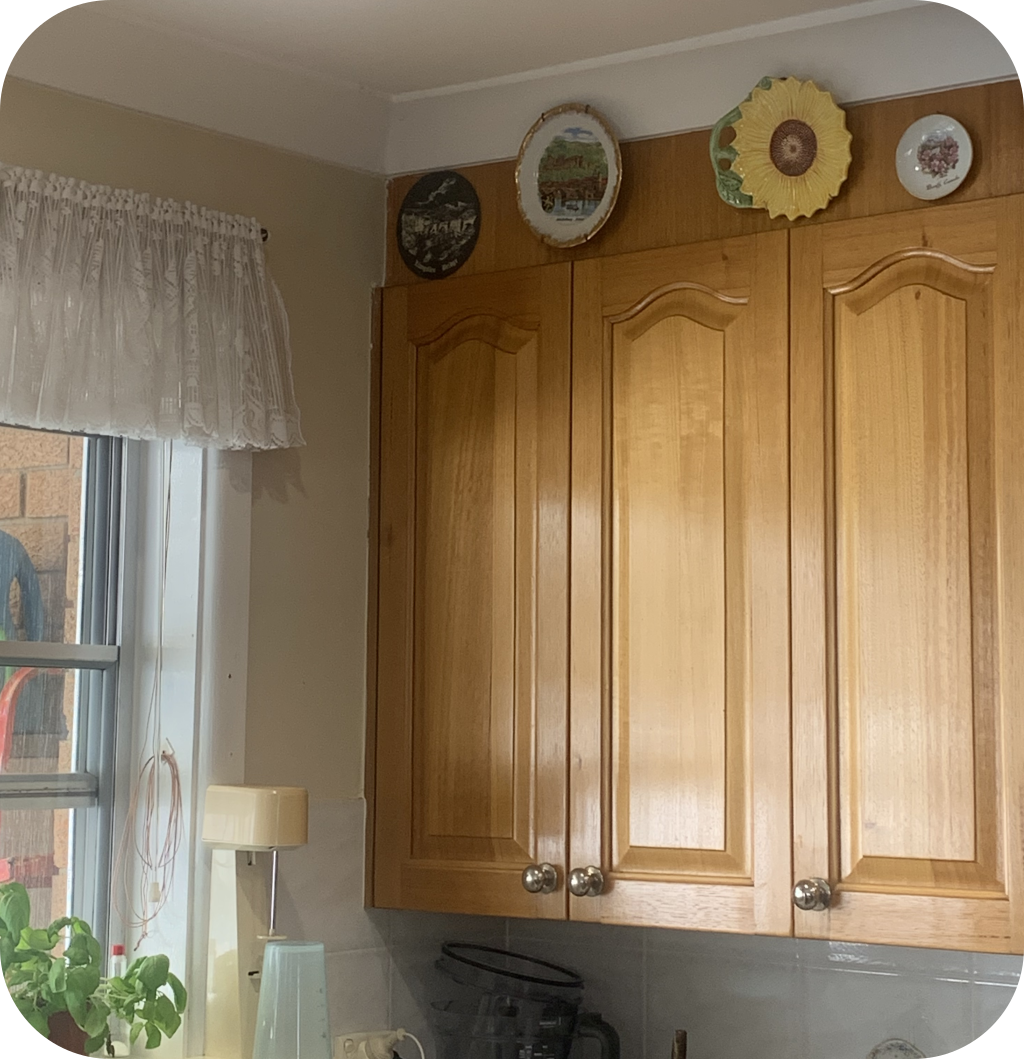 A brown kitchen cabinet with decorative plates above it.