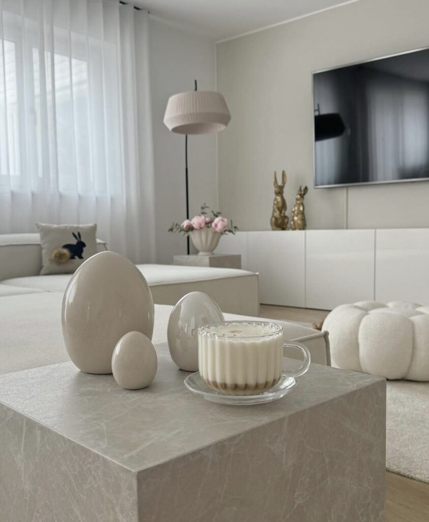A modern living room with gold bunny figurines and ceramic Easter eggs.