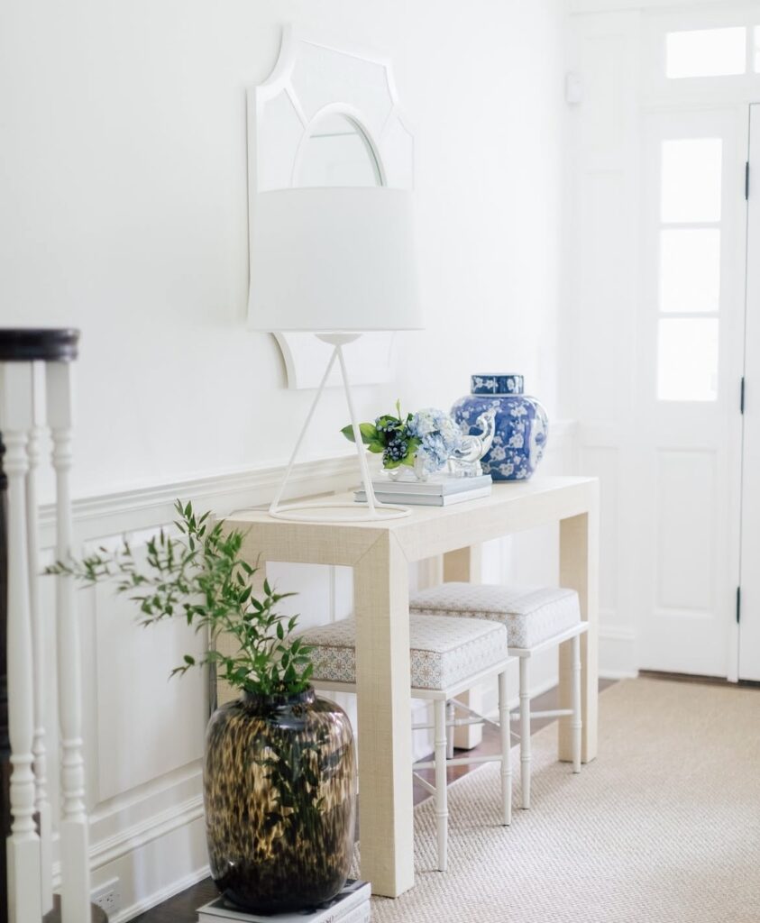 A white entryway with a blue vase.
