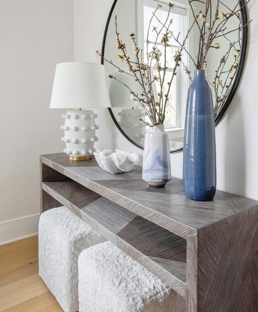 A modern entryway with blue vases and a large seashell.