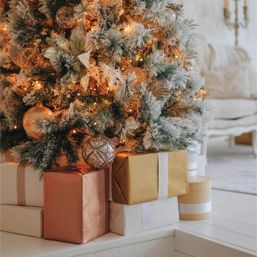 A Christmas tree with gold and warm toned gifts.