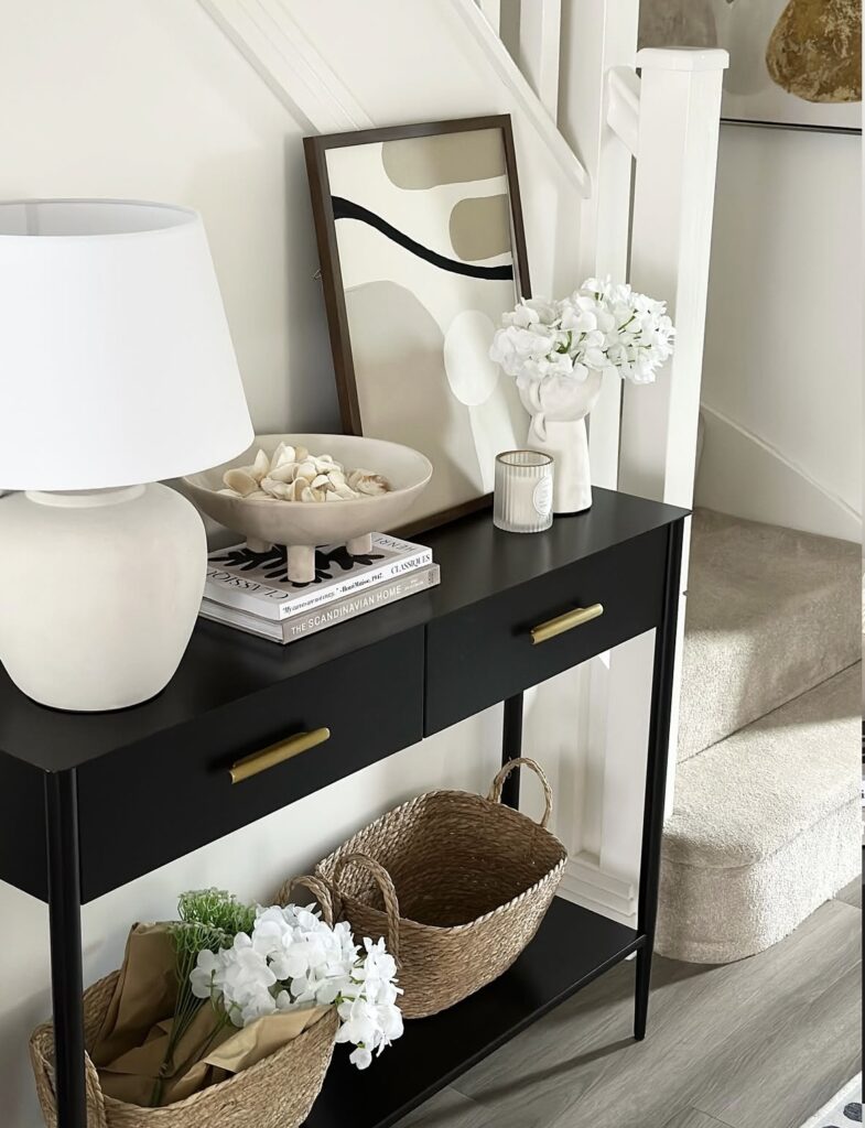 A black console table with a modern art print.