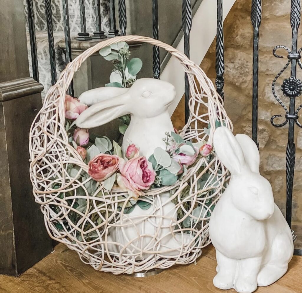 A white bunny figurine in a basket with faux flowers.