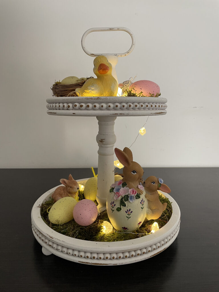 A white tray with Easter eggs and bunny figurines.