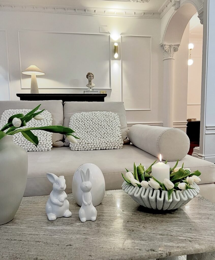 A white tray with white tulips and a white candle.