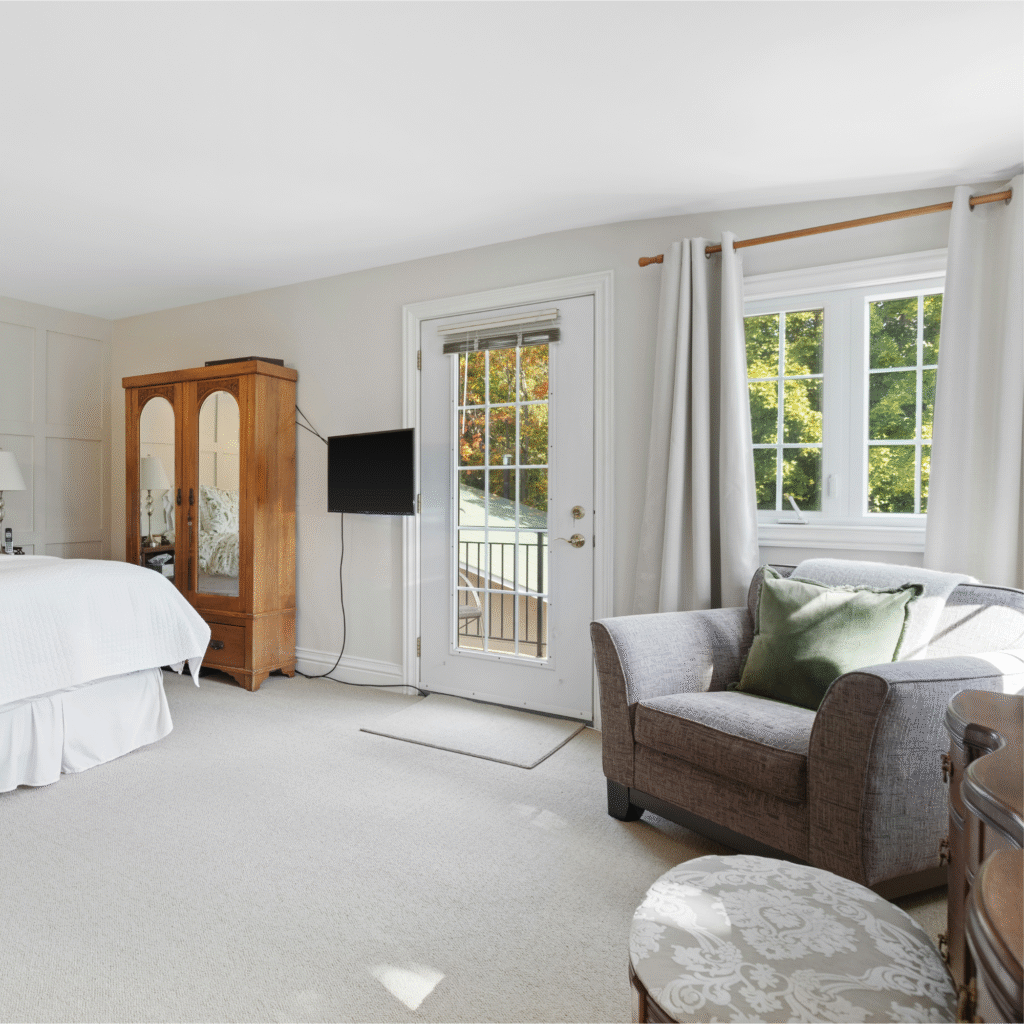 A bedroom with a gray armchair.