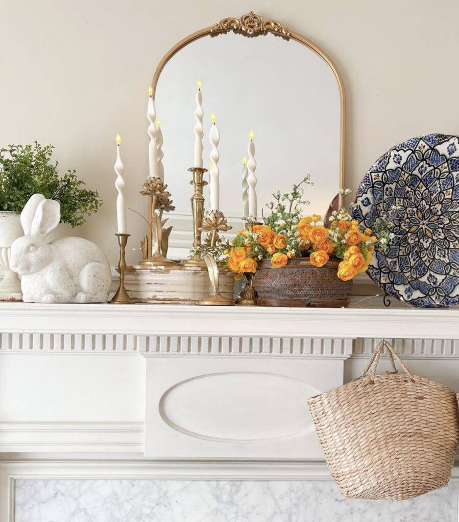 A white bunny with antique candle holders and a patterned plate.