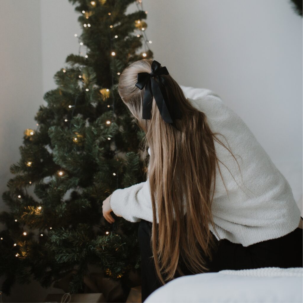 A woman decorating a Christmas tree.
