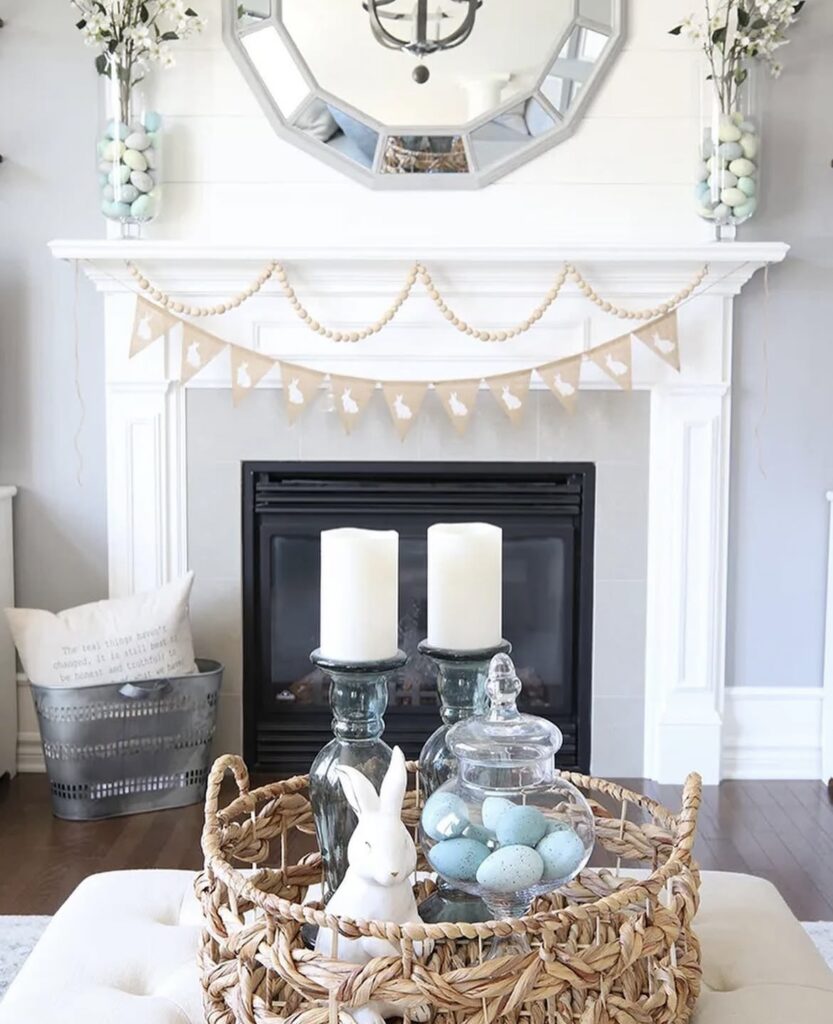 Blue Easter eggs in a glass vase with a white bunny figurine.
