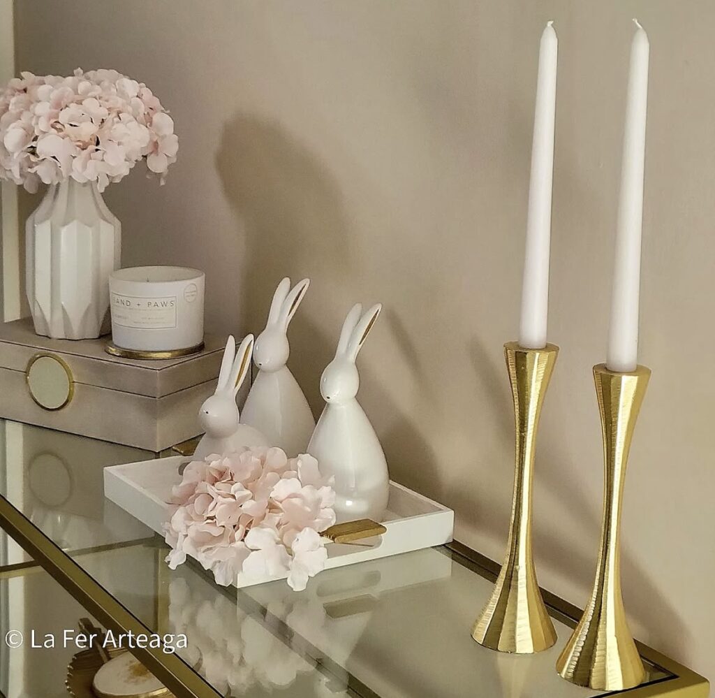 White bunny figurines with gold candle holders.